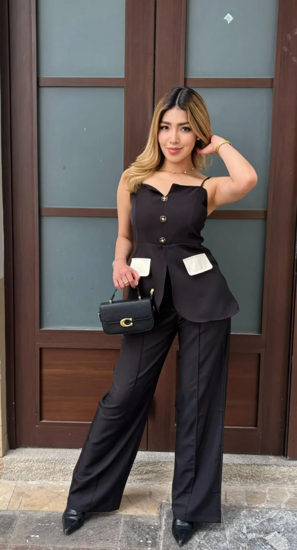 Modelo vistiendo el Conjunto Blazer Peplum de color negro con botones joya y pantalón wide leg de Heredia Showroom